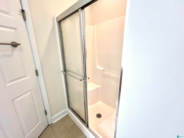 bathroom featuring tile patterned flooring and a shower with shower door