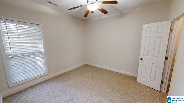 spare room featuring light carpet and ceiling fan