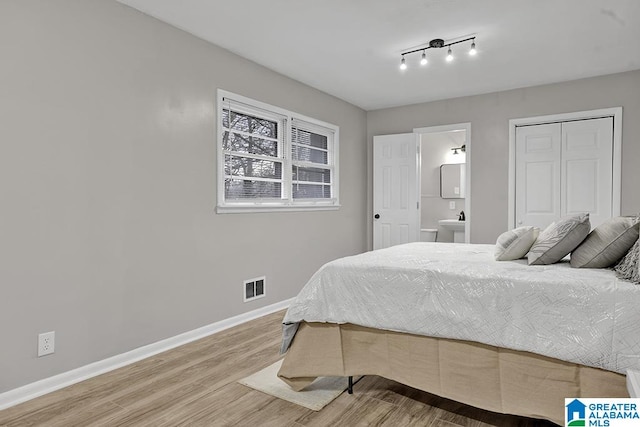 bedroom featuring hardwood / wood-style floors and ensuite bath