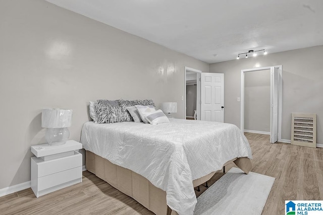 bedroom featuring light hardwood / wood-style floors and track lighting