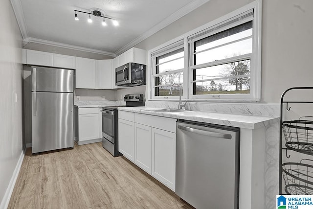 kitchen with white cabinets, light hardwood / wood-style floors, sink, and stainless steel appliances