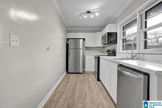 kitchen with white cabinets, light wood-type flooring, sink, and appliances with stainless steel finishes