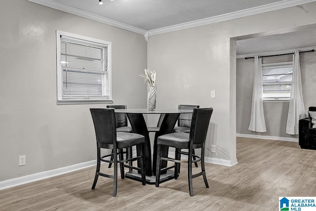 dining area featuring light wood-type flooring and ornamental molding