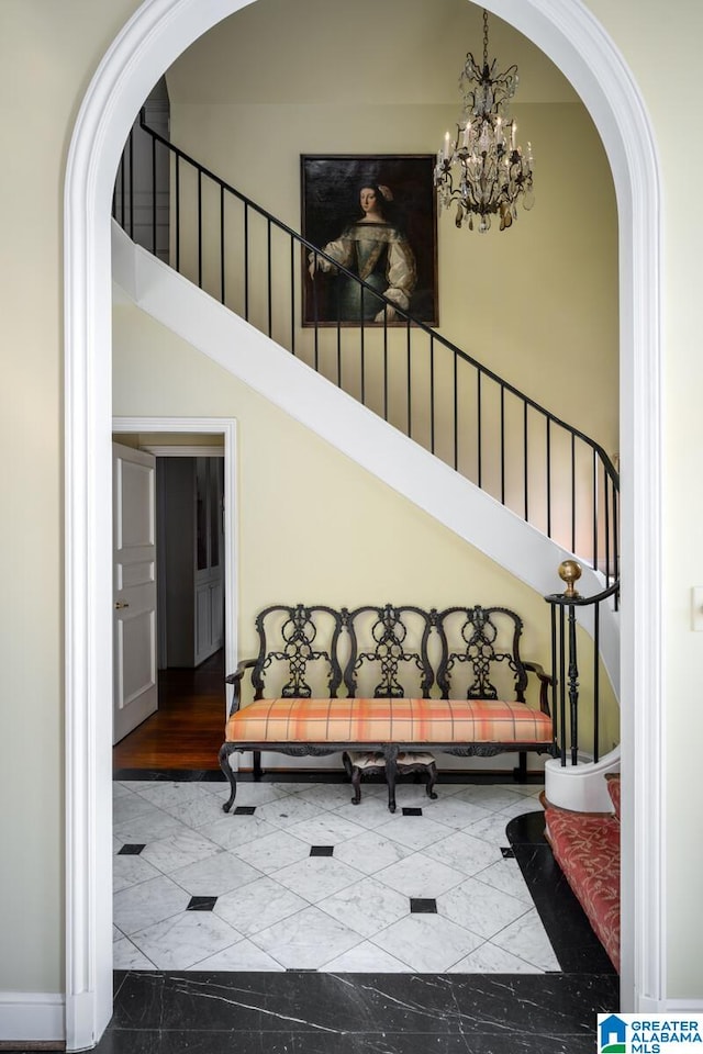 stairway with a towering ceiling and an inviting chandelier