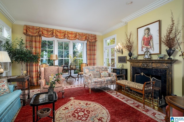 living area with hardwood / wood-style floors, a healthy amount of sunlight, ornamental molding, and a fireplace