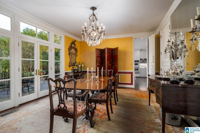 dining area with french doors, hardwood / wood-style flooring, ornamental molding, and a notable chandelier