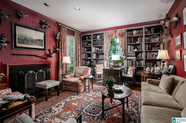 living area featuring hardwood / wood-style flooring, built in features, ornamental molding, and wood walls