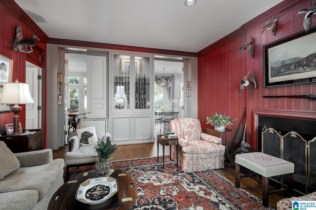 living room with dark hardwood / wood-style flooring, an inviting chandelier, and ornamental molding