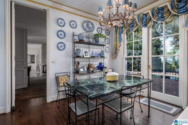 dining area featuring crown molding, dark wood-type flooring, and an inviting chandelier