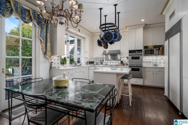 kitchen with white cabinets, plenty of natural light, a center island, and stainless steel appliances