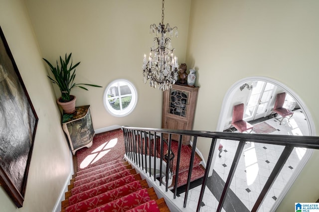 stairway featuring carpet flooring, a high ceiling, an inviting chandelier, and french doors