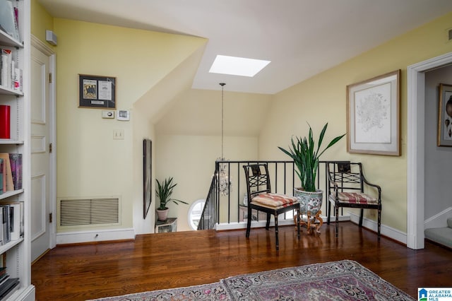 sitting room featuring lofted ceiling with skylight and dark wood-type flooring