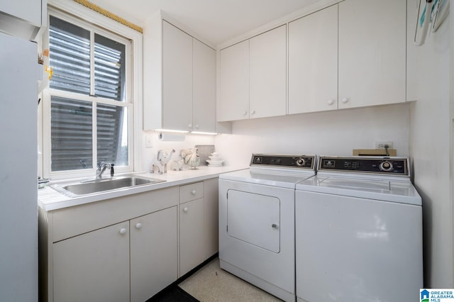 laundry area featuring cabinets, separate washer and dryer, and sink