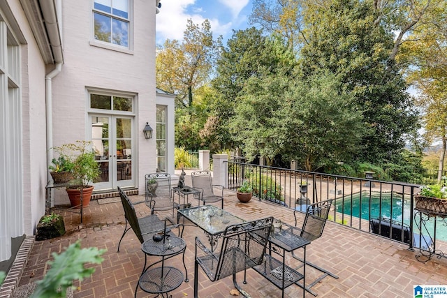 view of patio / terrace with french doors and a fenced in pool