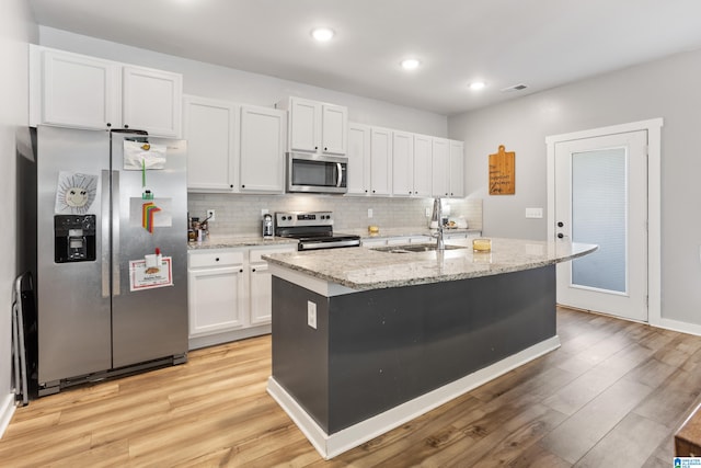 kitchen with stainless steel appliances, sink, a center island with sink, light hardwood / wood-style floors, and white cabinetry