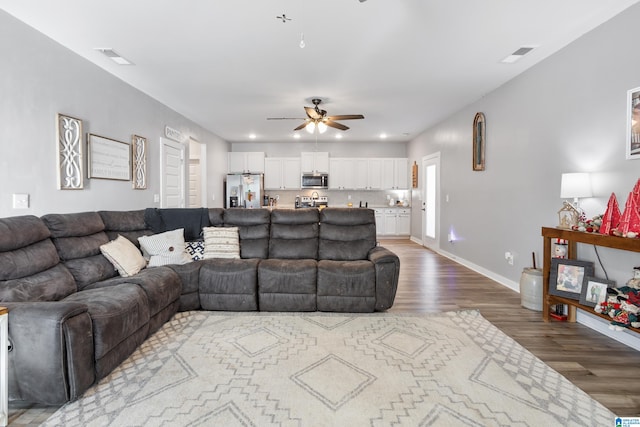 living room with wood-type flooring and ceiling fan