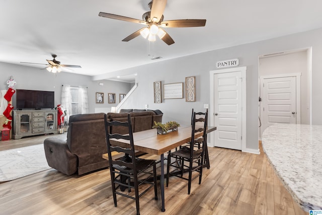 dining space with light hardwood / wood-style flooring and ceiling fan