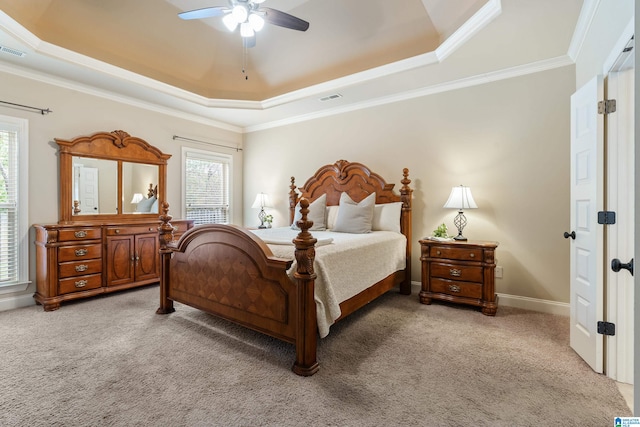 carpeted bedroom featuring ceiling fan, a raised ceiling, and crown molding