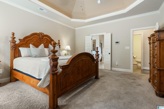 carpeted bedroom featuring ceiling fan, a raised ceiling, crown molding, and connected bathroom