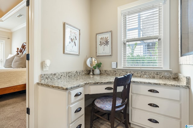 office with carpet flooring, built in desk, plenty of natural light, and ornamental molding