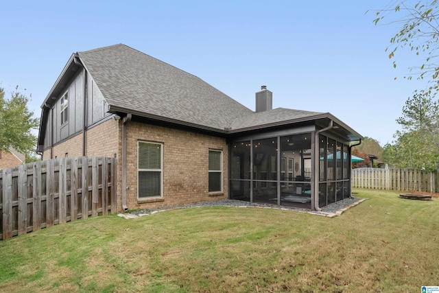 rear view of property featuring a sunroom and a yard