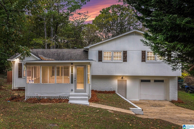 split level home with a yard and a garage