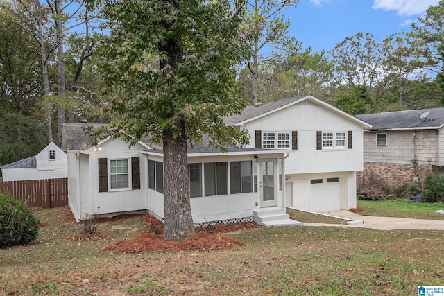 view of front facade featuring a sunroom, a garage, and a front lawn