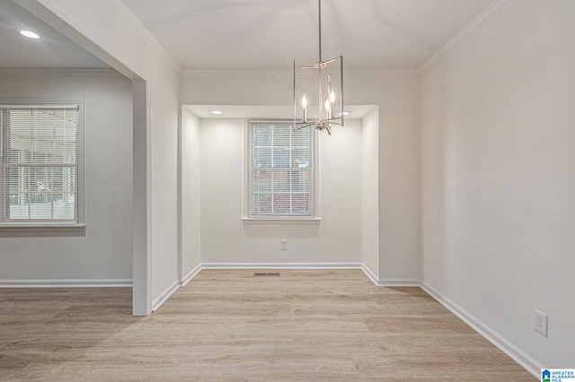 unfurnished dining area featuring a notable chandelier, light wood-type flooring, and ornamental molding