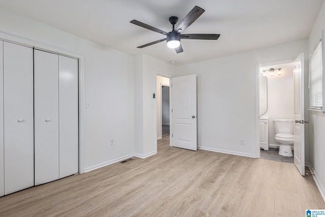 unfurnished bedroom with connected bathroom, ceiling fan, a closet, and light hardwood / wood-style floors