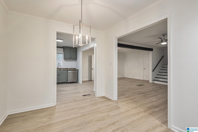 unfurnished dining area featuring ceiling fan with notable chandelier, light hardwood / wood-style floors, ornamental molding, and sink