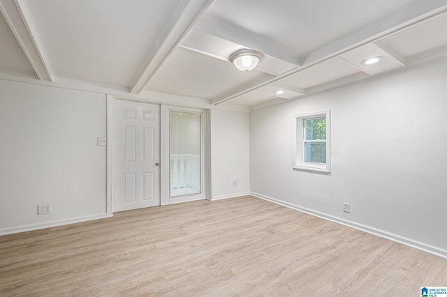 unfurnished room featuring beamed ceiling and light hardwood / wood-style flooring