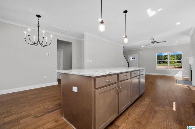 kitchen featuring light stone countertops, a center island, pendant lighting, and dark hardwood / wood-style floors