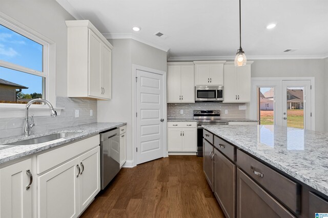 kitchen featuring ornamental molding, stainless steel appliances, sink, white cabinets, and dark hardwood / wood-style floors