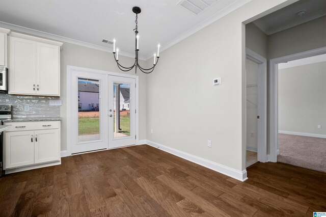 unfurnished dining area with dark hardwood / wood-style flooring, a chandelier, and ornamental molding