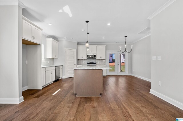 kitchen featuring dark wood-type flooring, white cabinets, hanging light fixtures, a kitchen island, and stainless steel appliances