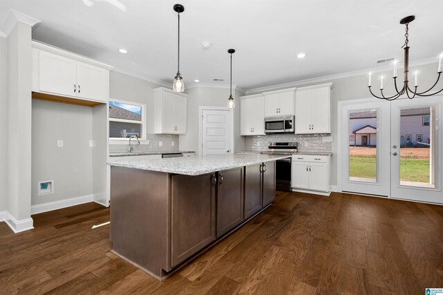 kitchen featuring plenty of natural light, dark hardwood / wood-style floors, white cabinetry, and stainless steel appliances