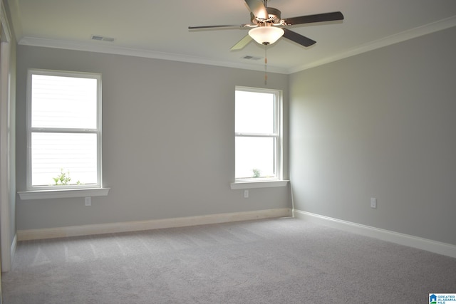 carpeted spare room with crown molding, ceiling fan, and a healthy amount of sunlight