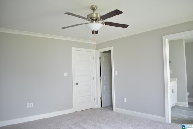 unfurnished bedroom with crown molding, ceiling fan, ensuite bathroom, and light carpet