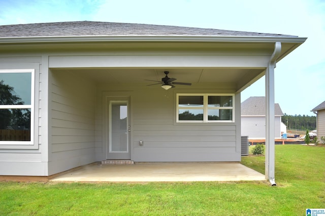 property entrance featuring ceiling fan, cooling unit, a patio area, and a yard