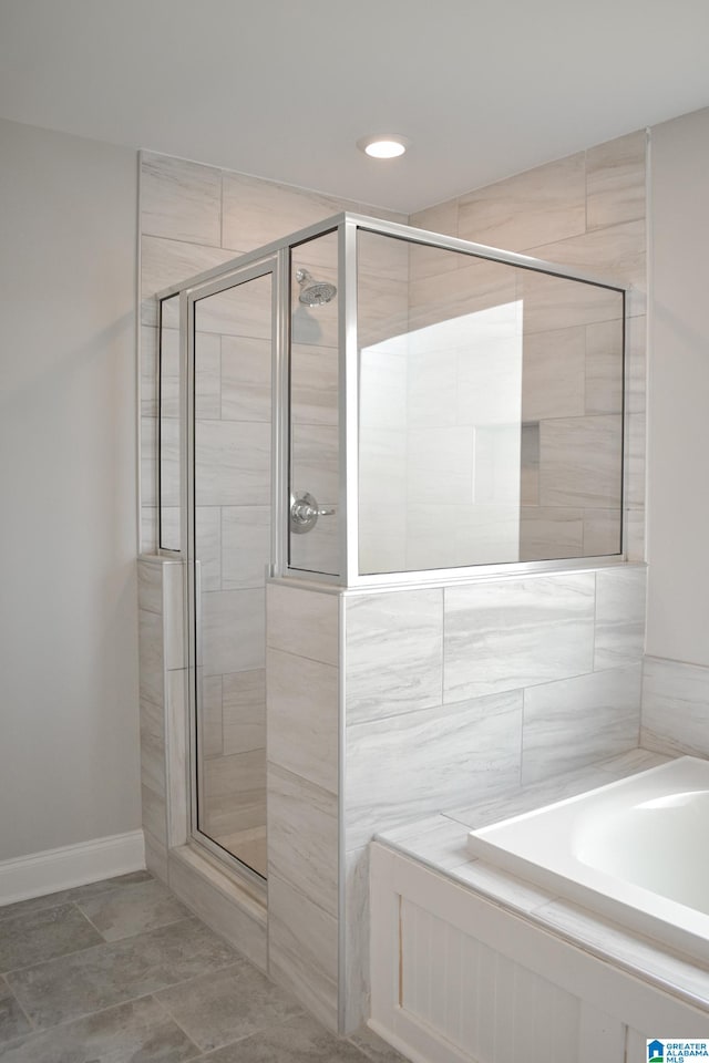 bathroom with shower with separate bathtub and tile patterned floors