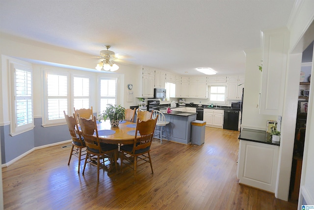 dining room with a textured ceiling, light wood-type flooring, and ceiling fan