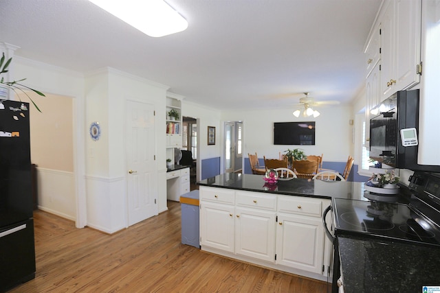 kitchen featuring light hardwood / wood-style floors, white cabinetry, a healthy amount of sunlight, and black appliances