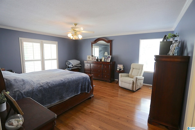 bedroom featuring hardwood / wood-style flooring, ceiling fan, crown molding, and a textured ceiling