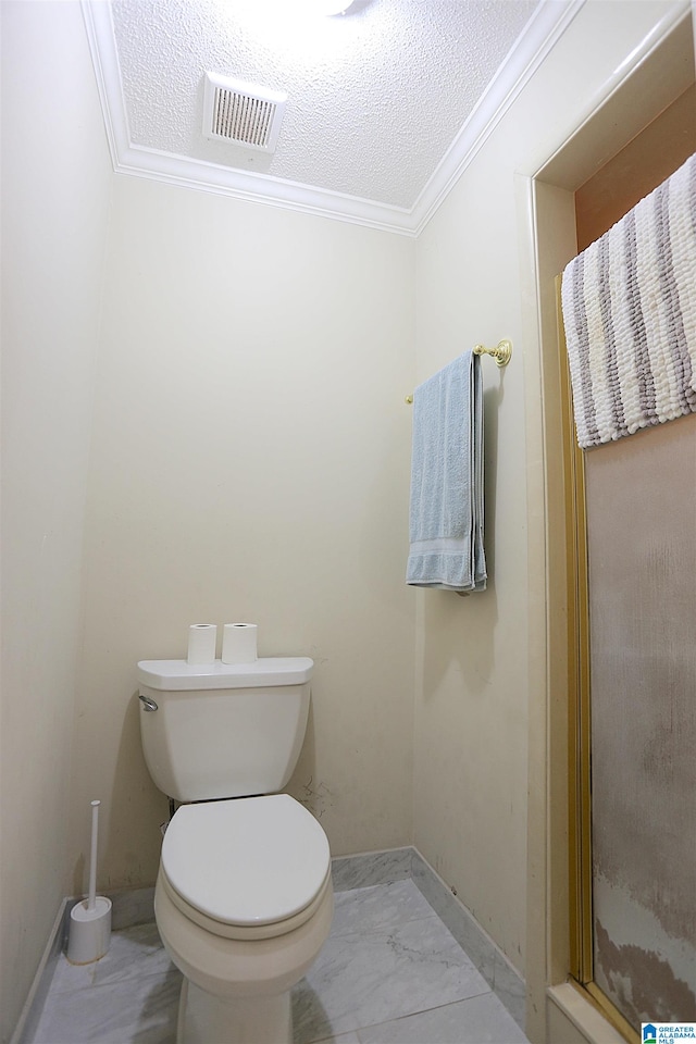 bathroom with toilet, crown molding, and a textured ceiling