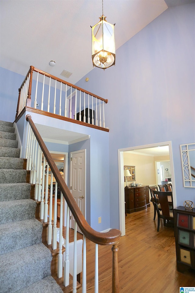 staircase featuring wood-type flooring and a towering ceiling