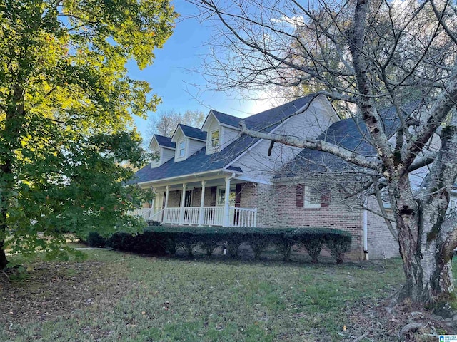 view of side of home featuring covered porch and a yard