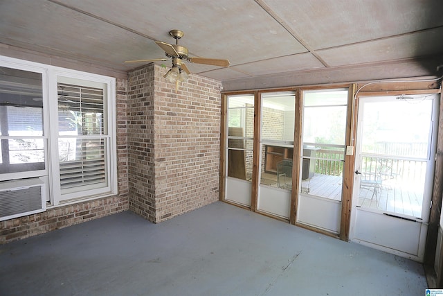 unfurnished sunroom featuring a wealth of natural light, cooling unit, and ceiling fan