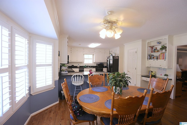 dining area with dark hardwood / wood-style floors, ceiling fan, and crown molding