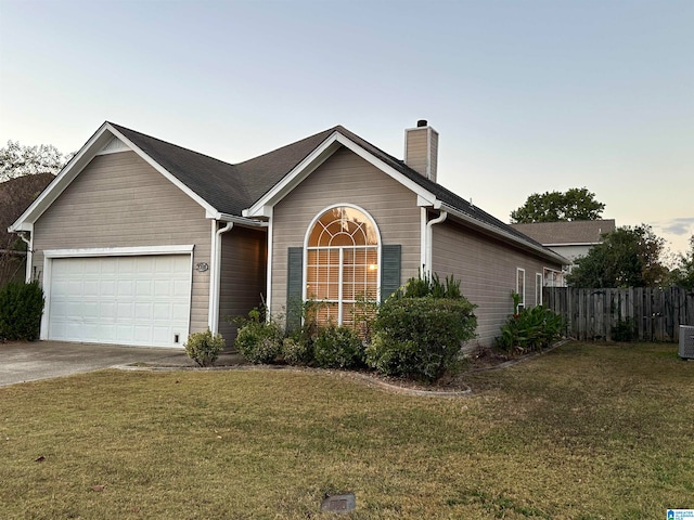 ranch-style house with a yard and a garage