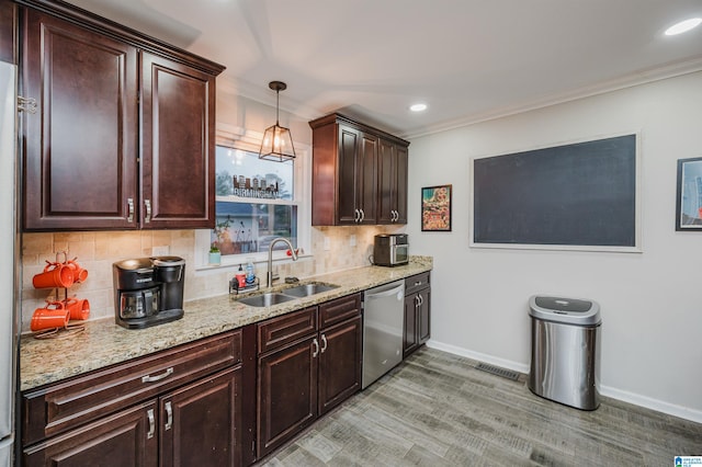 kitchen featuring pendant lighting, dishwasher, sink, ornamental molding, and light hardwood / wood-style floors